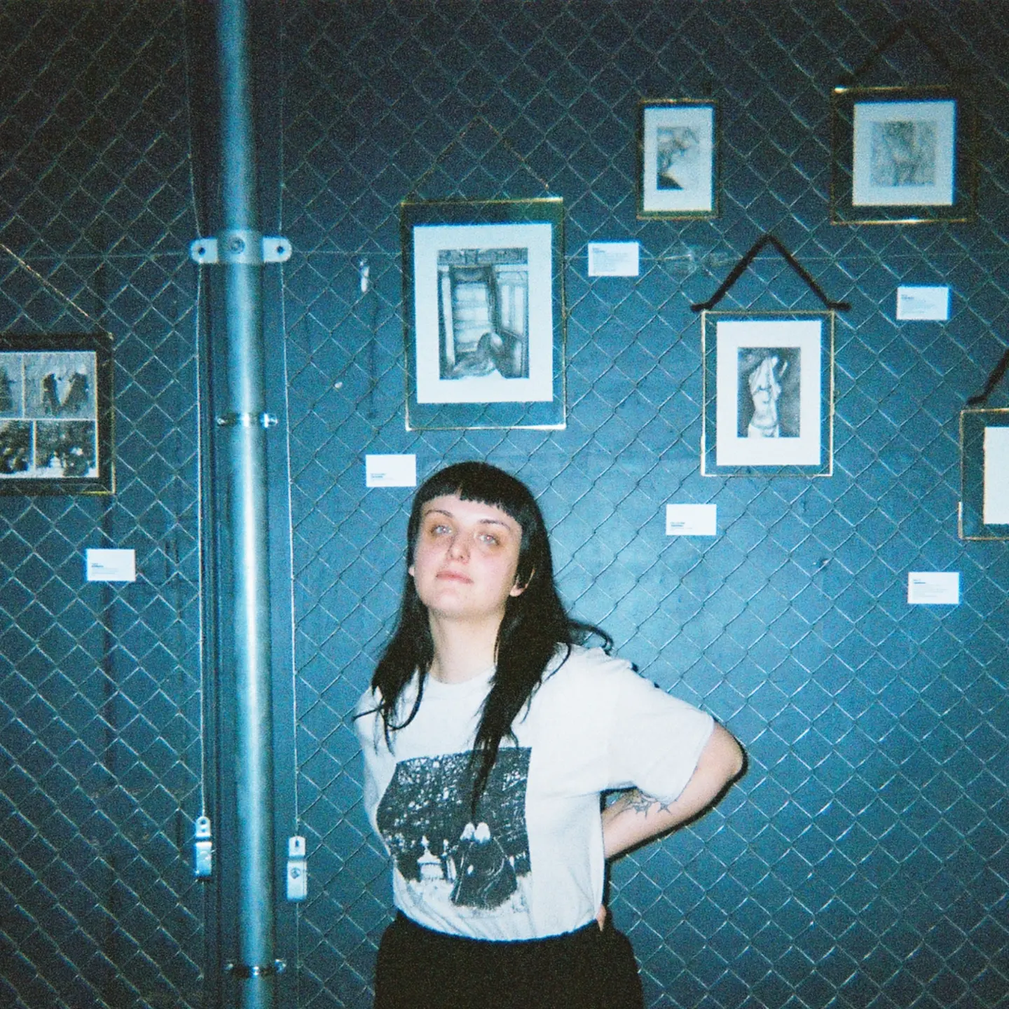 Portrait de Camille Viala, l'artiste, devant ses originaux lors d'une exposition
